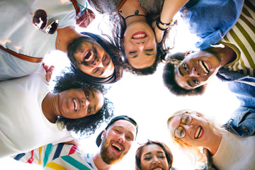 Group of smiling faces looking down in circle
